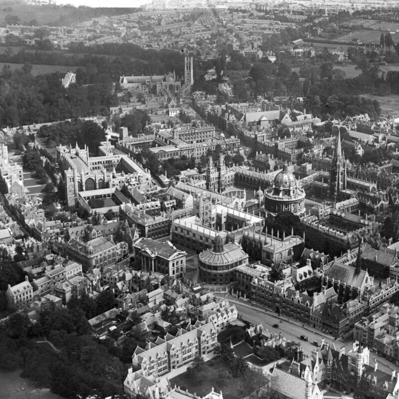 A black and white aerial photograph of a town.