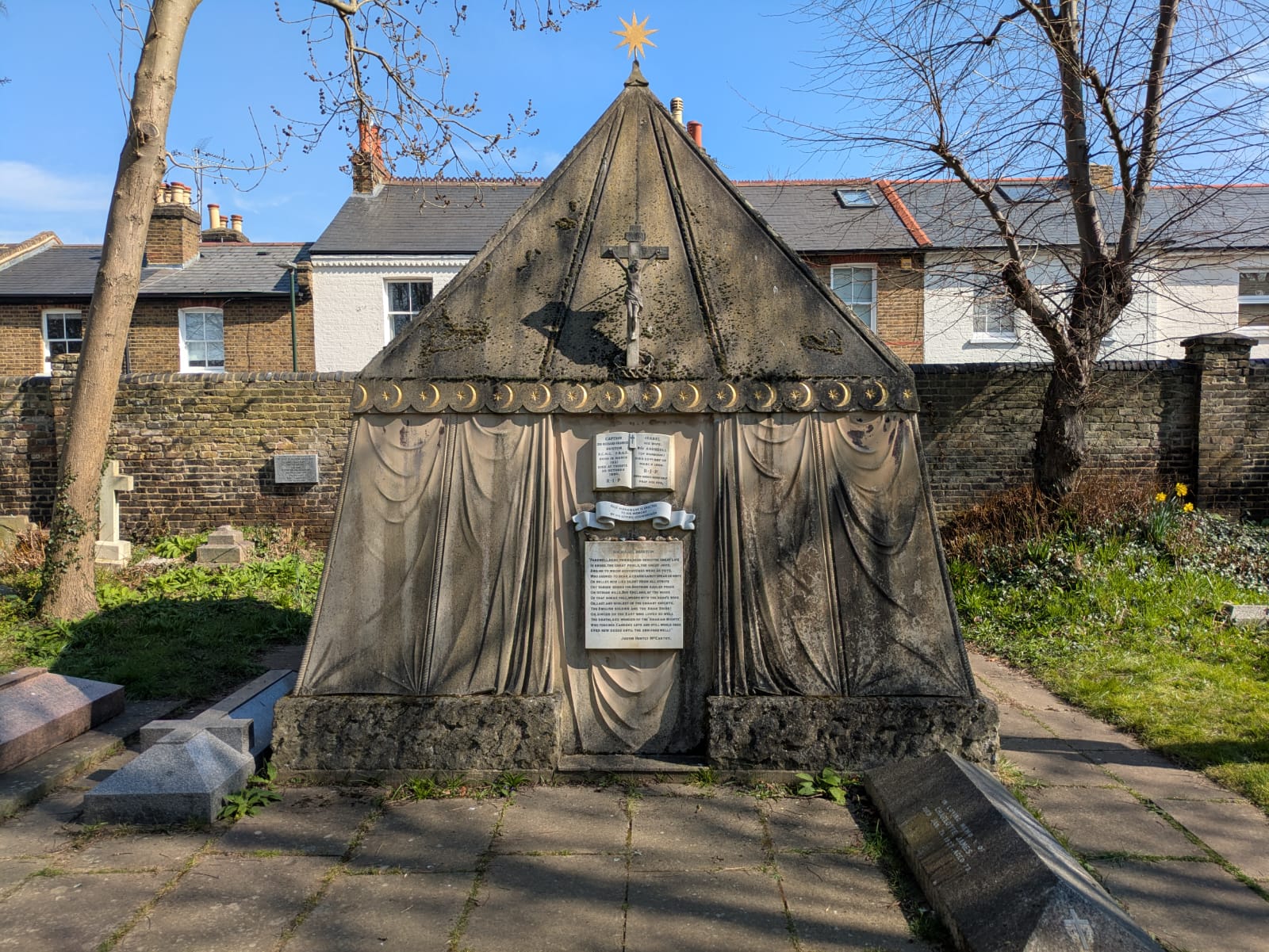 A photograph of the exterior of the tomb which is made of stone and shaped like a nomadic tent.