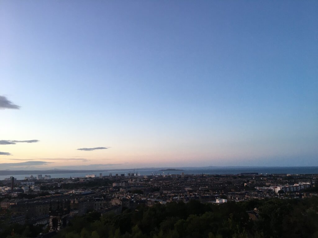 Photograph of Edinburgh skyline at sunset, with many historic buildings shown.