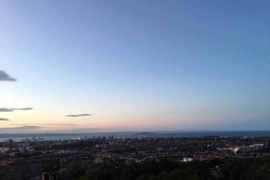 Photograph of Edinburgh skyline at sunset, with many historic buildings shown.