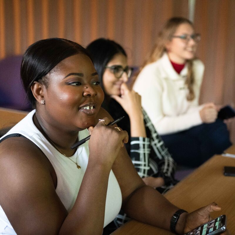 Young women smiling facing sideways on to the camera