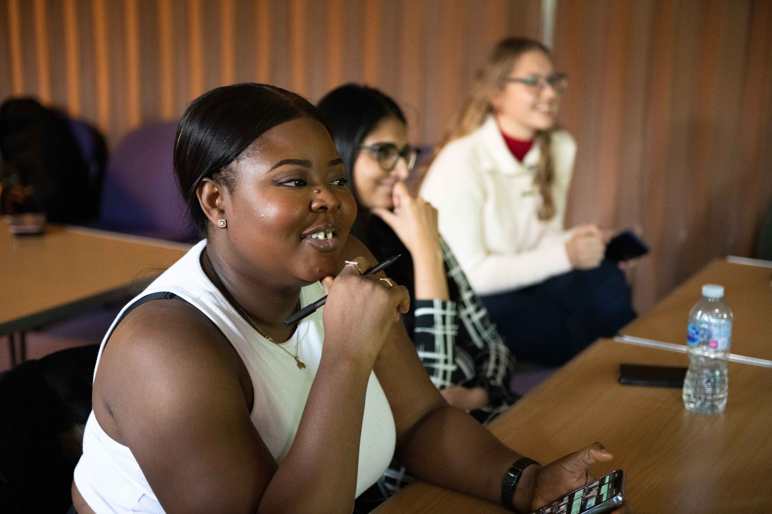 Young women smiling facing sideways on to the camera