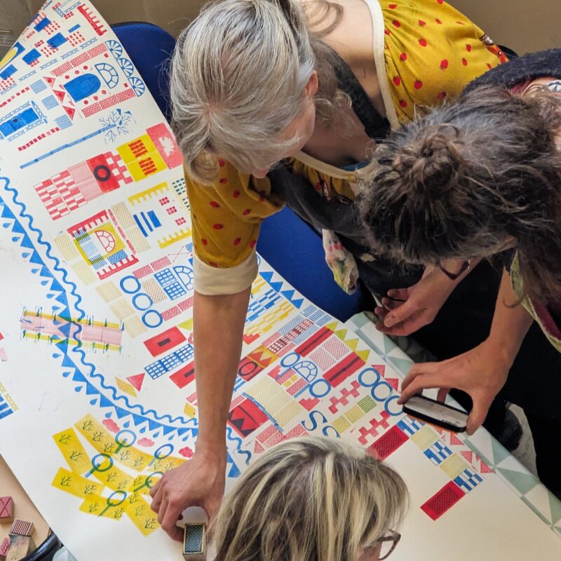 a group of people making an art piece from stencils