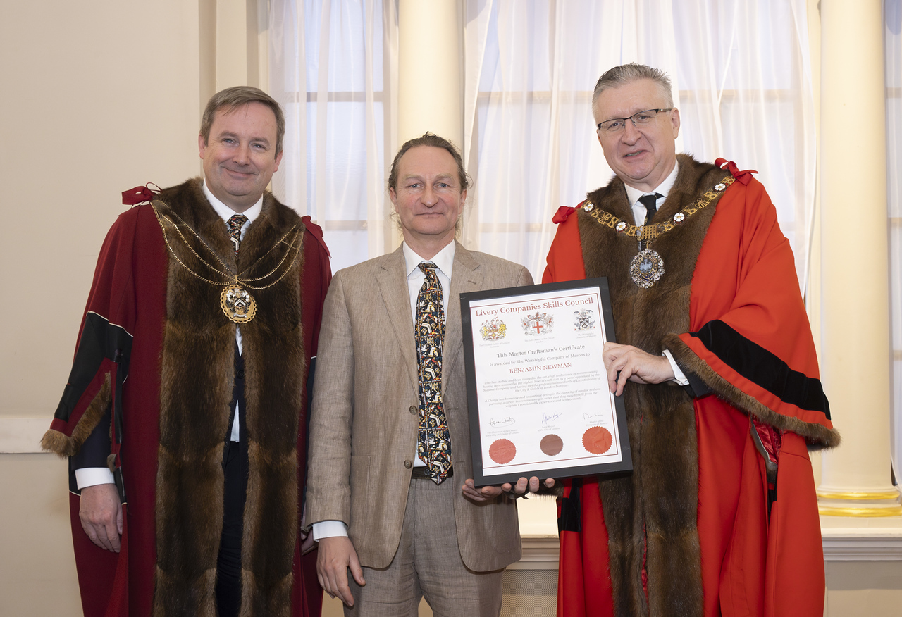 A photograph of Ben receiving his award. He is flanked by two gentlemen in ceremonial robes and chains.
