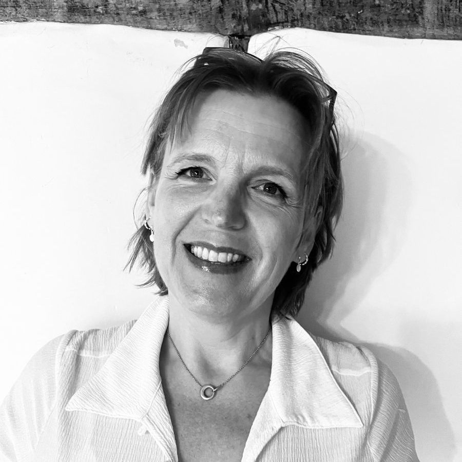 A black and white photo of Claire Robison, she is looking directly to the camera and smiling