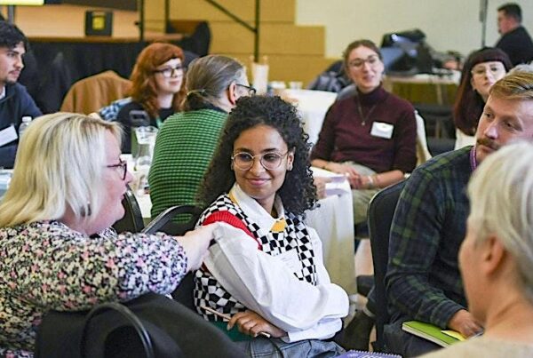 A group of people chatting at a round table at conference