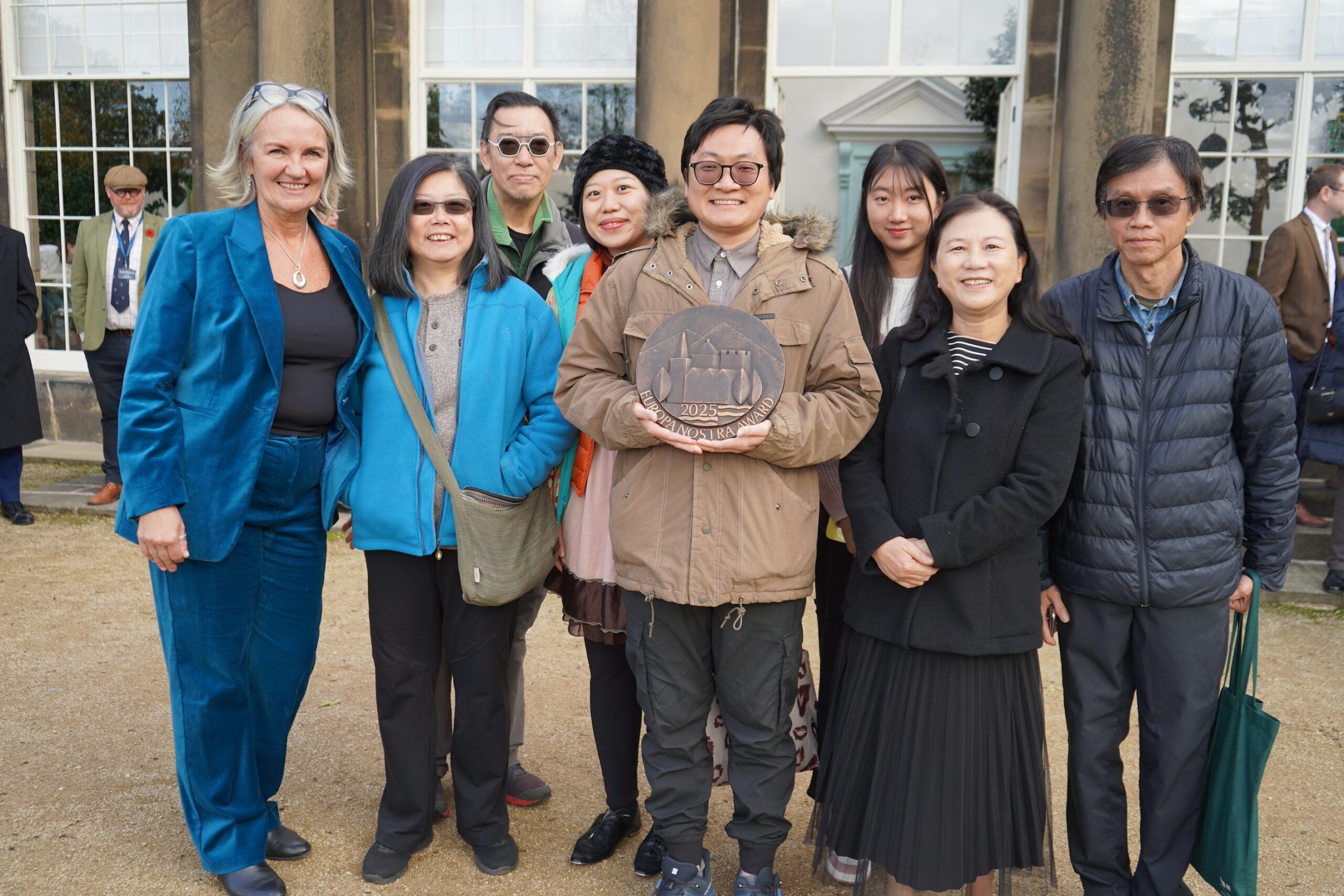 Staff from Wentworth Woodhouse and a group from the Chinese community stand in a group displaying the Europa Nostra award.