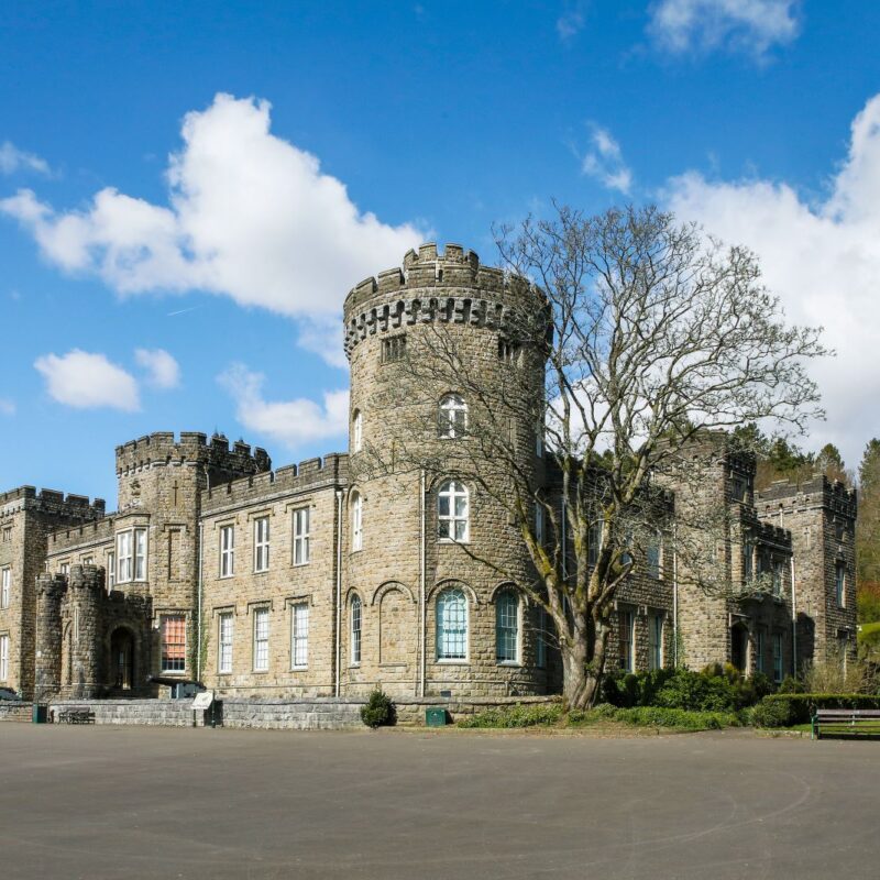 Cyfarthfa Castle with a blue sky in the background with fluffy white clouds.