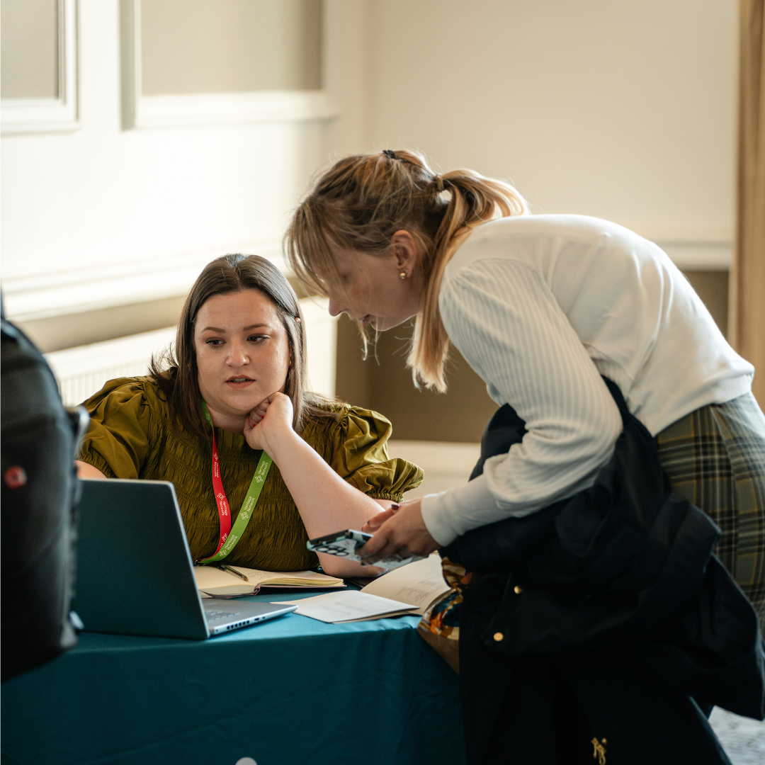 Photograph of a Heritage Network member of staff helping a conference delegate