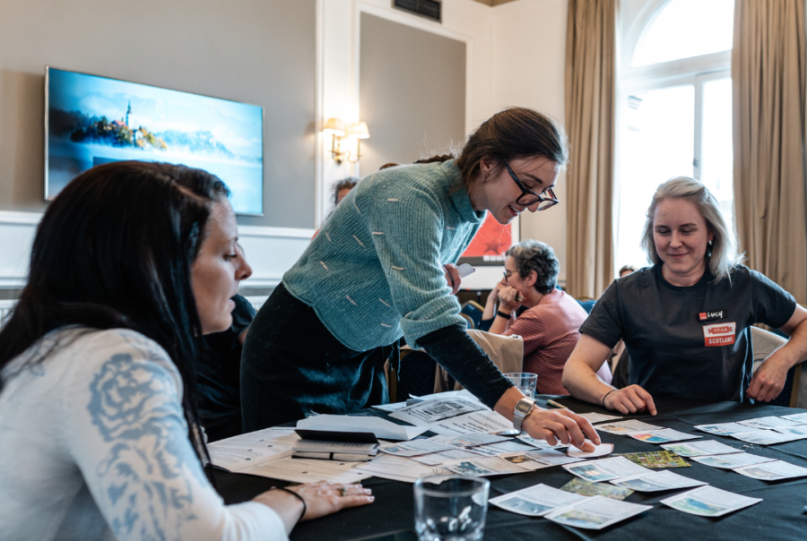 Photograph of a conference workshop, groups of people are working together to complete a task.