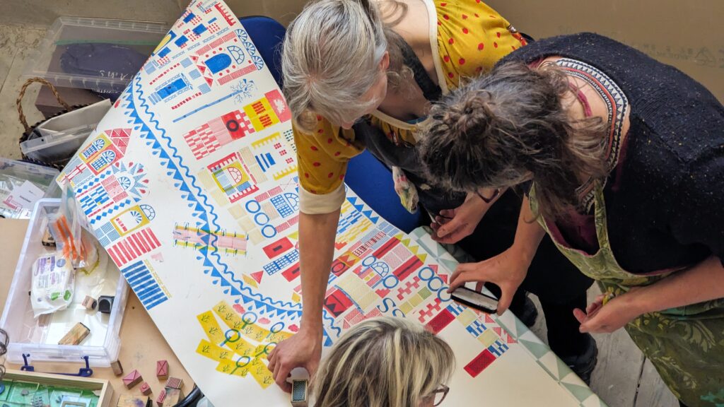 a group of people making an art piece from stencils