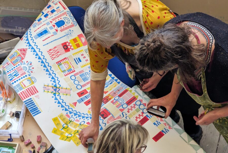 a group of people making an art piece from stencils